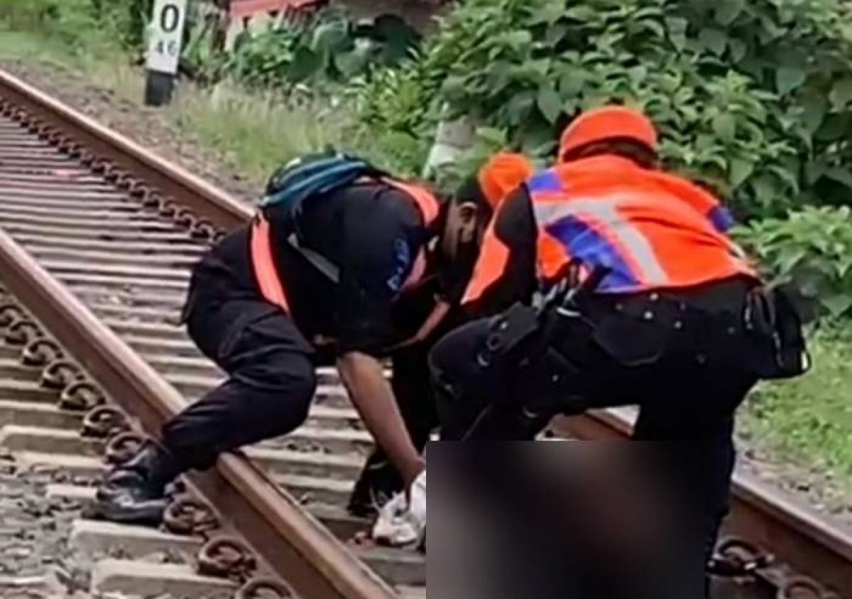 Petugas mengevakuasi jenazah wanita yang tertabrak kereta api di Kota Malang. (Foto: PSC Kota Malang for jatimnow.com)