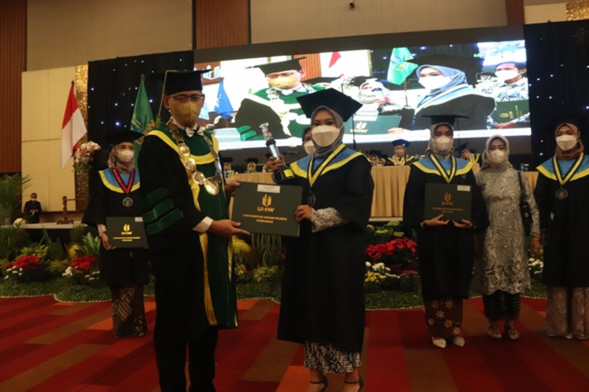 Rektor Universitas Hayam Wuruk Perbanas Dr Yudi Sutarso memberikan penghargaan pada wisudawan terbaik Febriyani Sarwindah. (Foto: Humas Universitas Hayam Wuruk Perbanas/jatimnow.com)