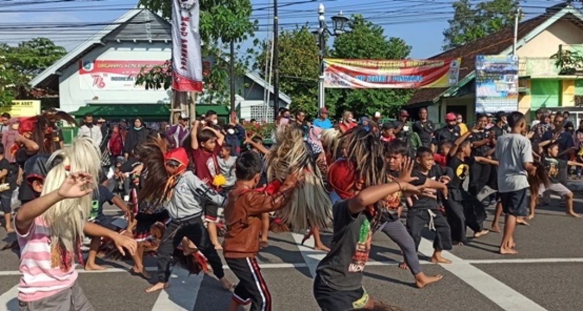 Aksi menari Bujang Ganong di Jalan HOS Cokroaminoto, Minggu (19/6/2022).yang diikuti ratusan siswa SD.