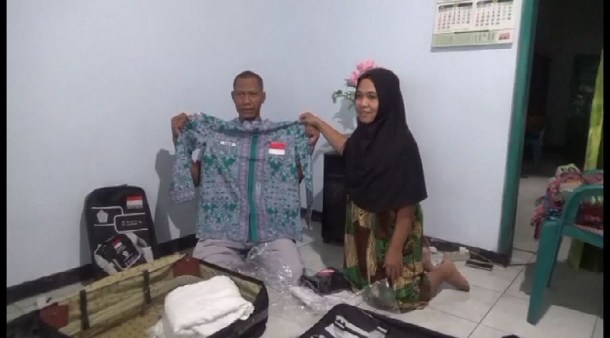 Amir dan Mariyam saat menunjukkan baju haji yang akan dikenakan nanti saat pergi haji.(Foto: Elok Aprianto)
