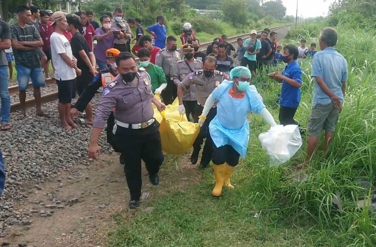 Petugas mengevakuasi jenazah korban tersambar kereta api di Tulungagung. (Foto: Bramanta Pamungkas/jatimnow.com)