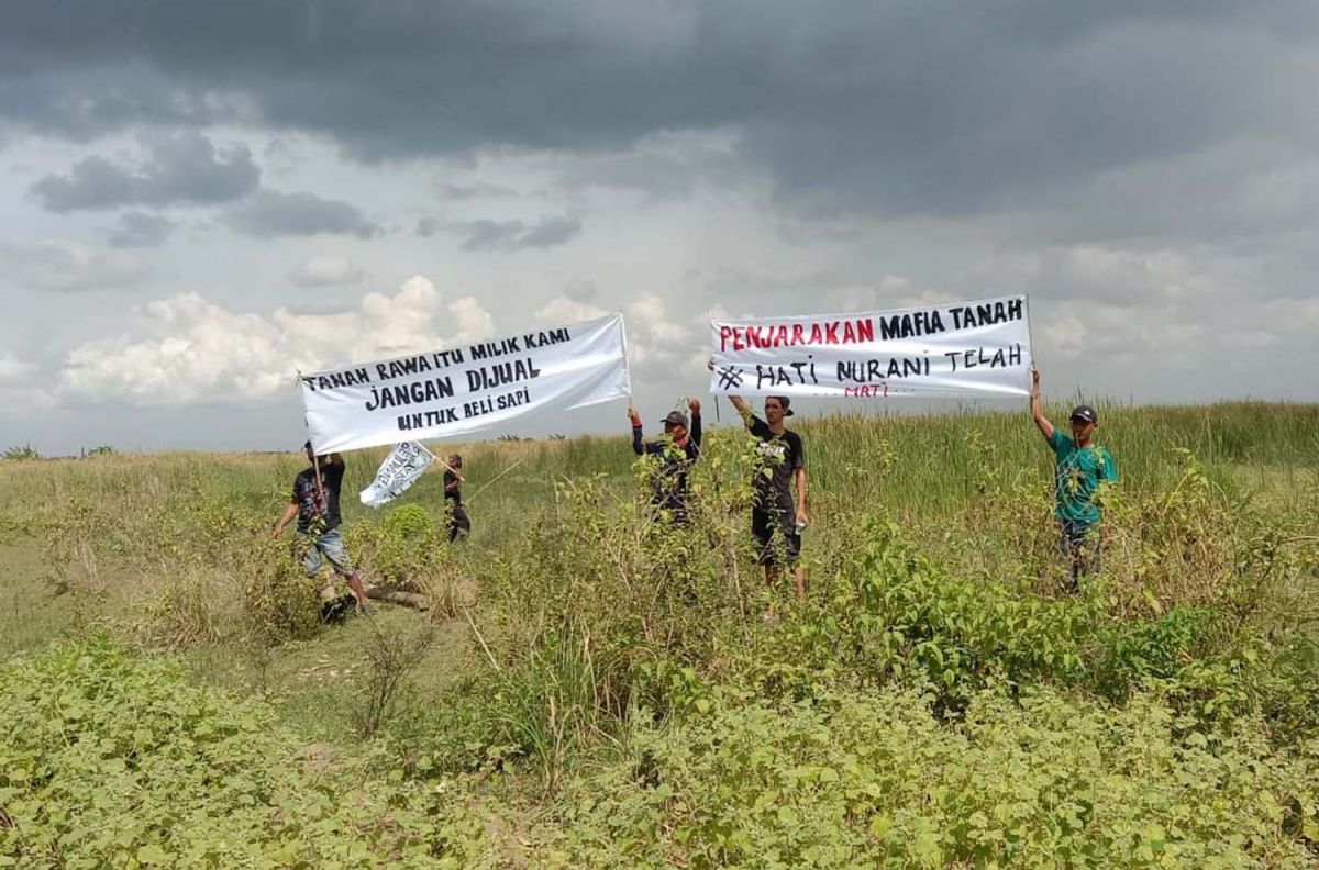 Warga Desa Dateng, Kecamatan Laren, Kabupaten Lamongan saat menggelar unjuk rasa di Rawa Jabung Dyke dan balai desa setempat