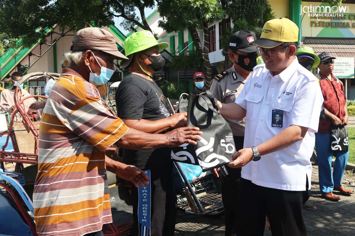 Direktur Utama PT Petrokimia Dwi Satriyo Annurogo saat memberikan bantuan uang tunai kepada tukang becak