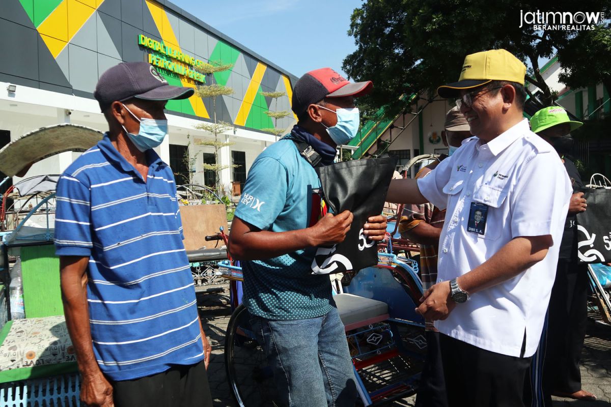 Direktur Utama PT Petrokimia Dwi Satriyo Annurogo saat memberikan bantuan uang tunai kepada tukang becak