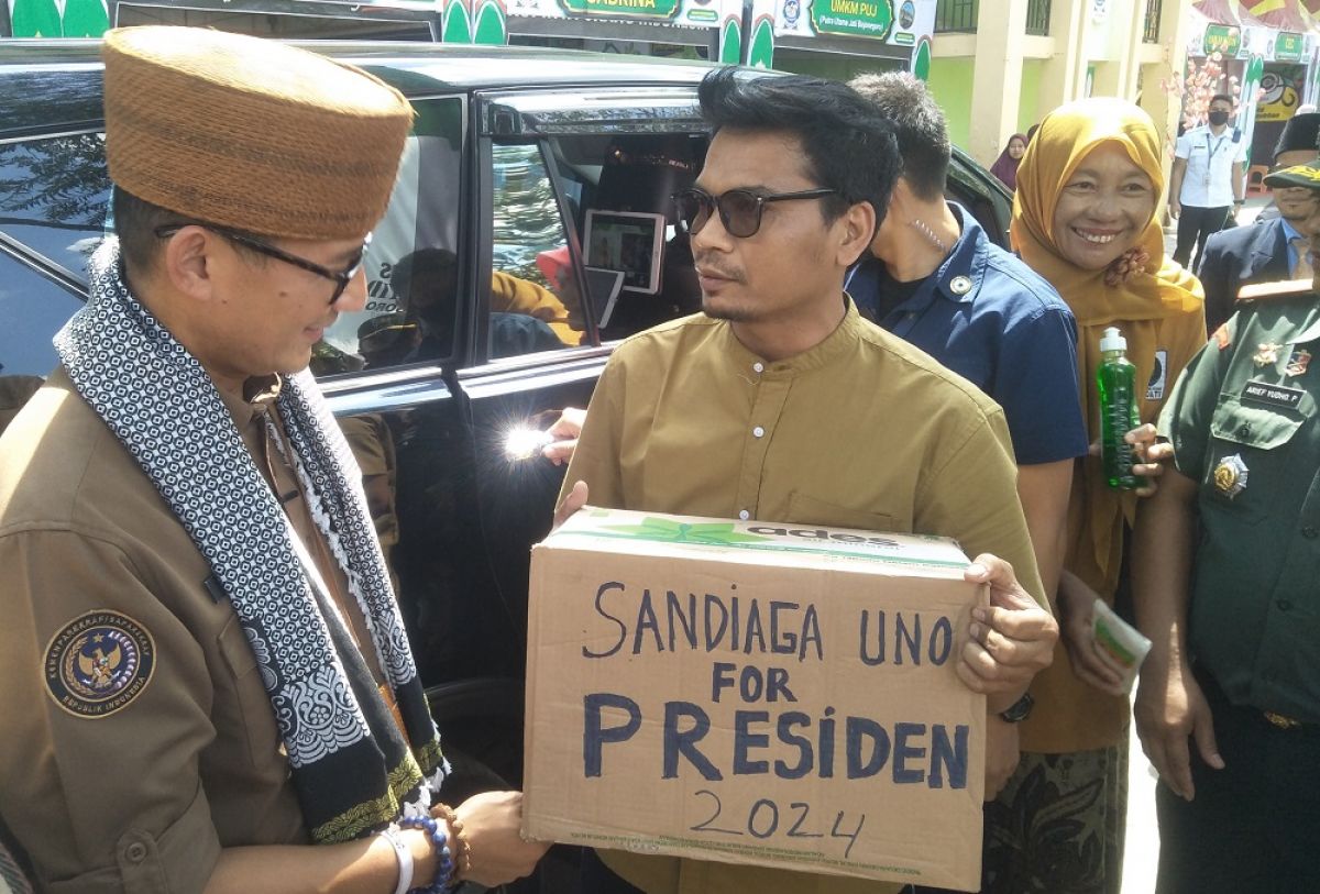Yanto pelaku UMKM membawa kardus bertuliskan Sandiaga Uno For Presiden 2024 saat Sandiaga hendak pergi meninggalkan Ponpes Ar Rosyid. (Foto: Misbahul munir/jatimnow.com)