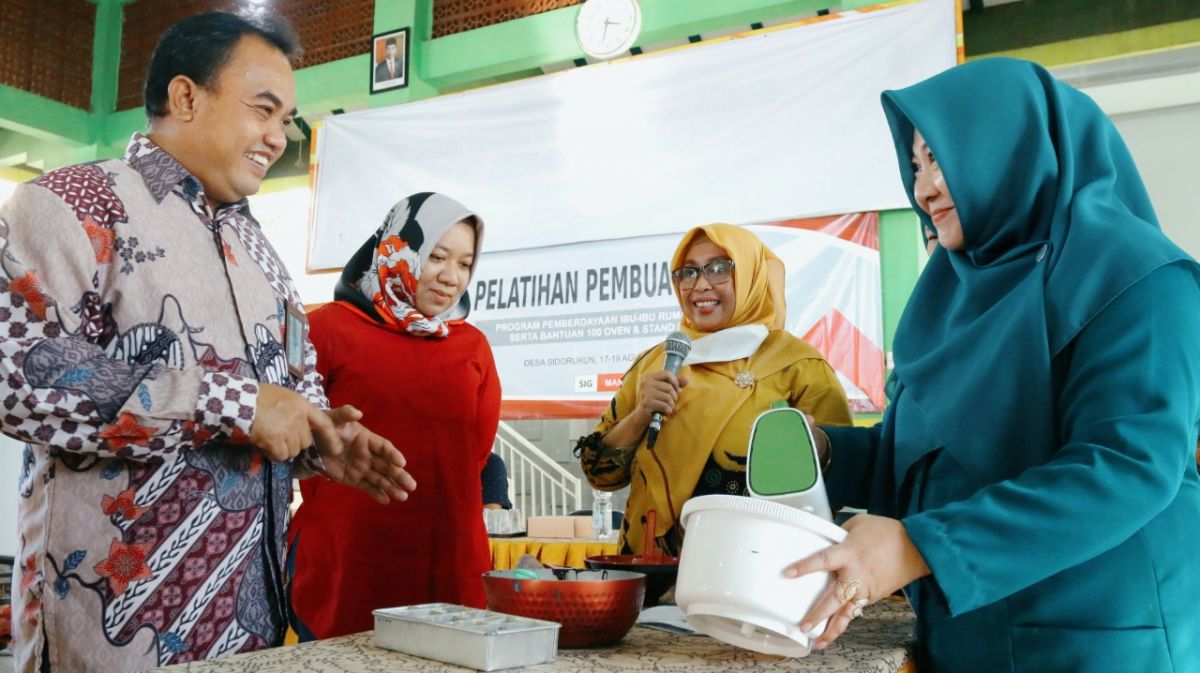 General Manager of CSR SIG Edy Saraya (kiri) didampingi Kepala Bidang Koperasi dan Usaha Mikro Dinas Koperasi, Usaha Mikro dan Perindag Kabupaten Gresik, Fransiska Dyah Ayu (dua dari kiri) melihat praktik pelatihan pembuatan kue di Desa Sidorukun. (Foto: SIG for jatimnow.com)