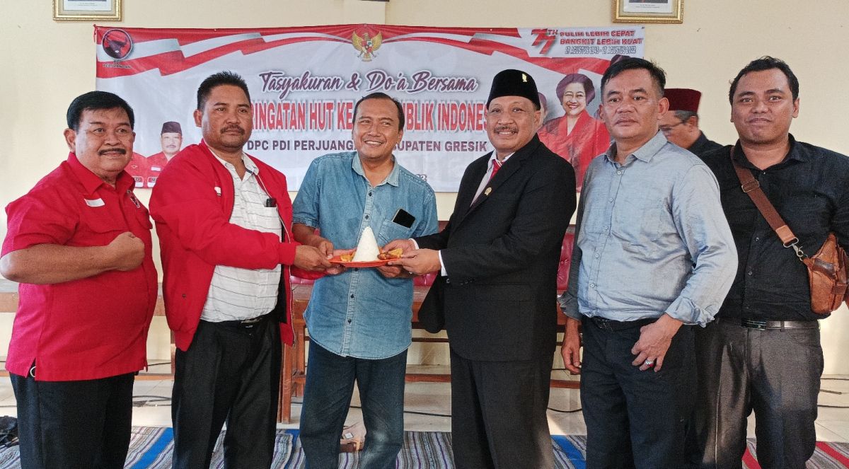 Ketua PDI Perjuangan Kabupaten Gresik menyerahkan potongan tumpeng kepada perwakilan wartawan.(Foto: Sahlul Fahmi/jatimnow.com)