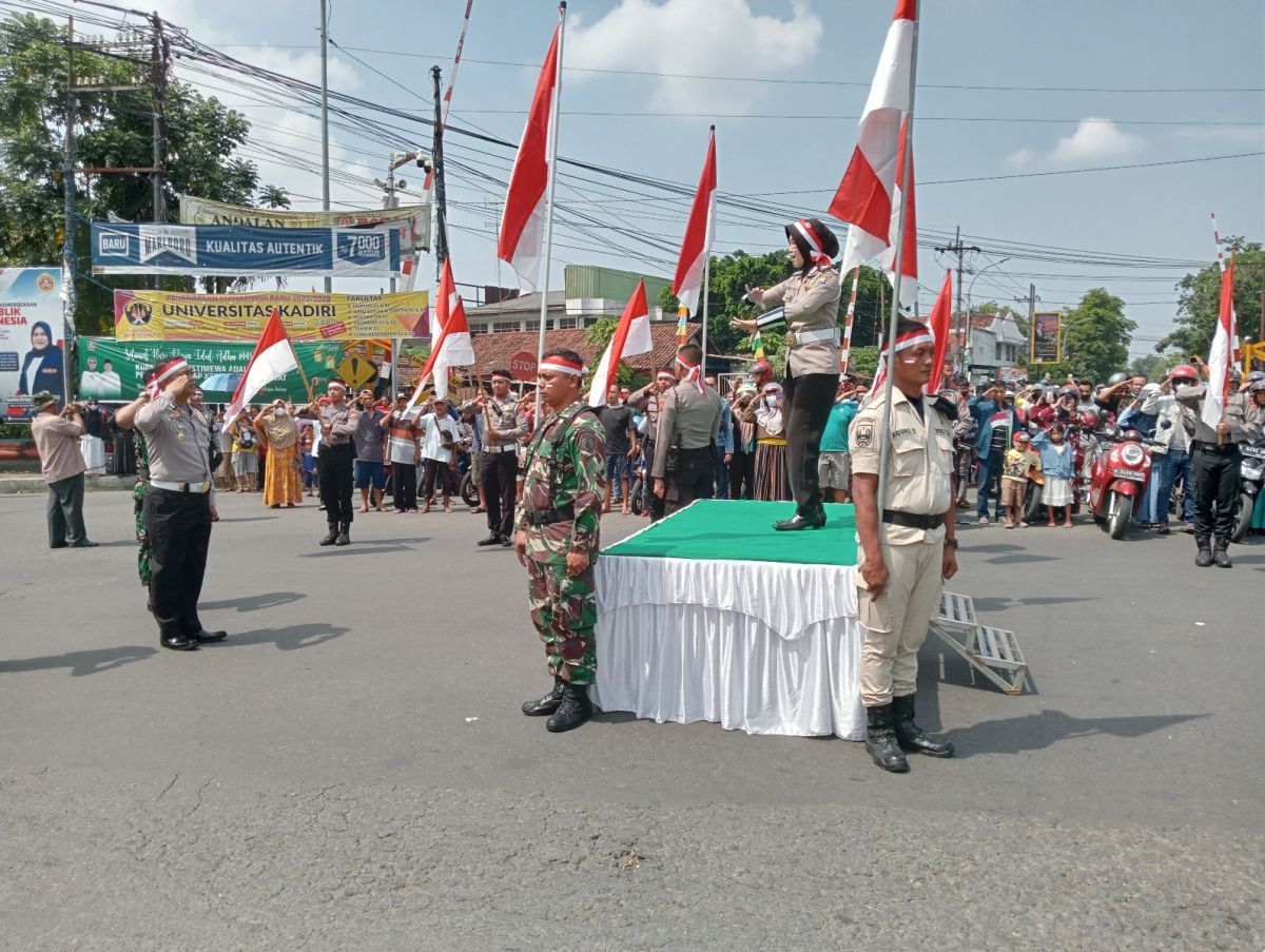 Ratusan warga dan pengguna jalan di jalur Nasional Surabaya-Madiun saat hormat Bendera Merah Putih saat detik-detik proklamasi.(Foto: Elok Aprianto)