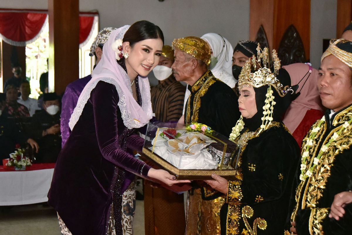 Ketua TP PKK Trenggalek Novita Hardini menyerahkan kado pernikahan dan akta nikah