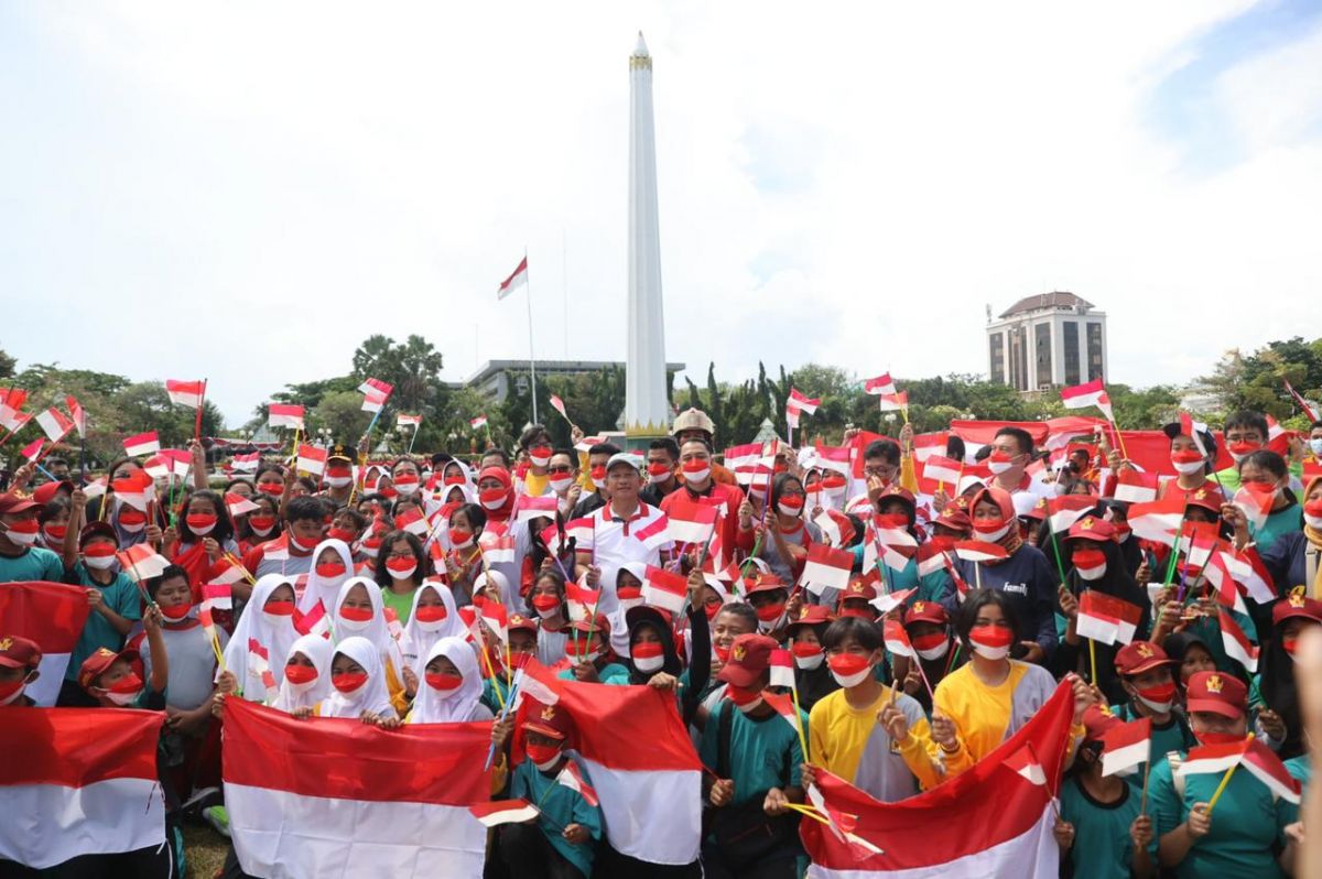 Gubernur Jawa Timur Khofifah Indar Parawansa bersama Mendagri Tito Karnavian berbagi bendera kepada masyarakat