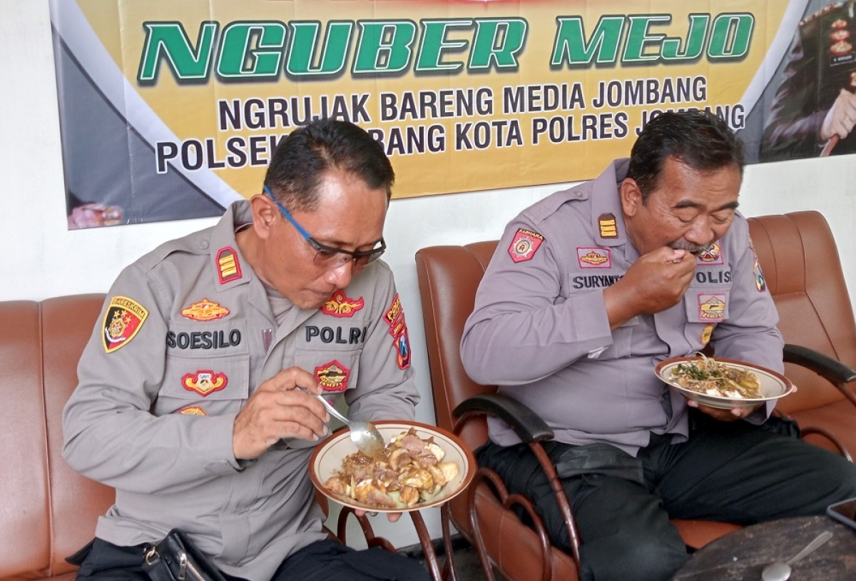 Kapolsek Jombang AKP Soesilo bersama anggotanya saat menikmati rujak legendaris Bu Bokin. (Foto: Elok Aprianto/jatimnow.com)