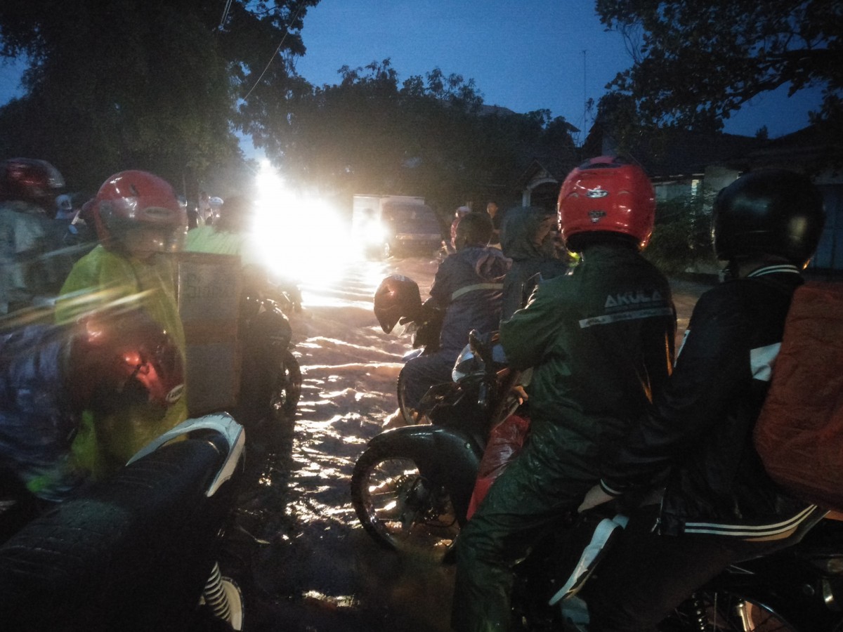 Pengguna jalan menunggu air surut di Jalan Raya Bojonegoro-Nganjuk, Desa Kunci, Kecamatan Dander, Kabupaten Bojonegoro