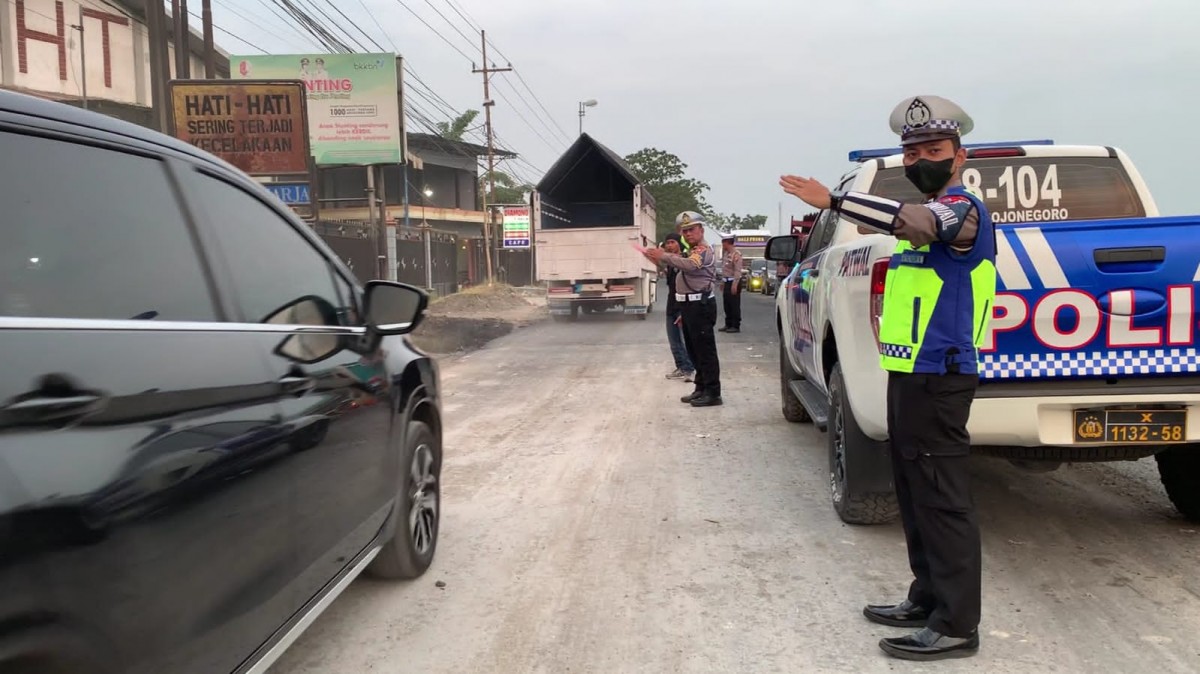 Sejumlah petugas kepolisian mengurai kemacetan akibat pelebaran jalan di Jalan Bojonegoro-Babat. (foto: Humas Polres Bojonegoro for jatimnow.com)