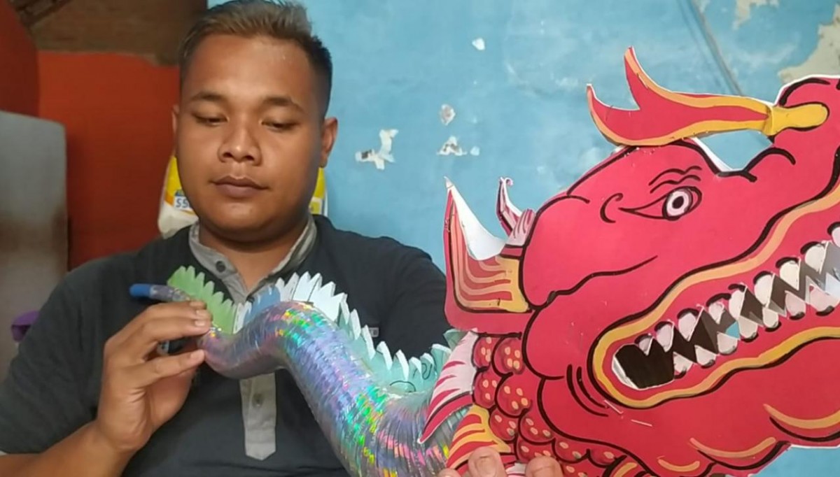 Supardi saat menyelesaikan terompet di rumahnya. (foto: Elok Aprianto/jatimnow.com)