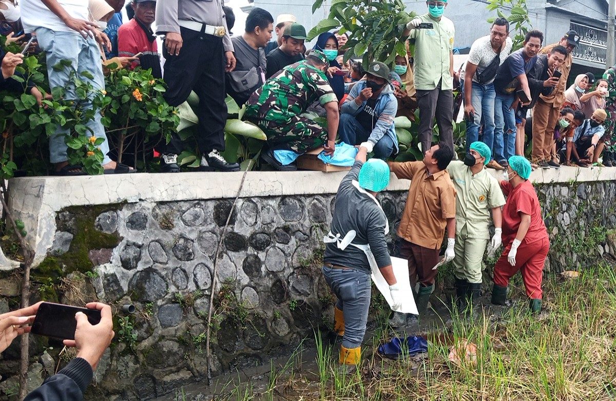 Warga Siwalanpanji, Buduran, Sidoarjo, menyaksikan dari dekat proses evakuasi temuan jasad bayi. 