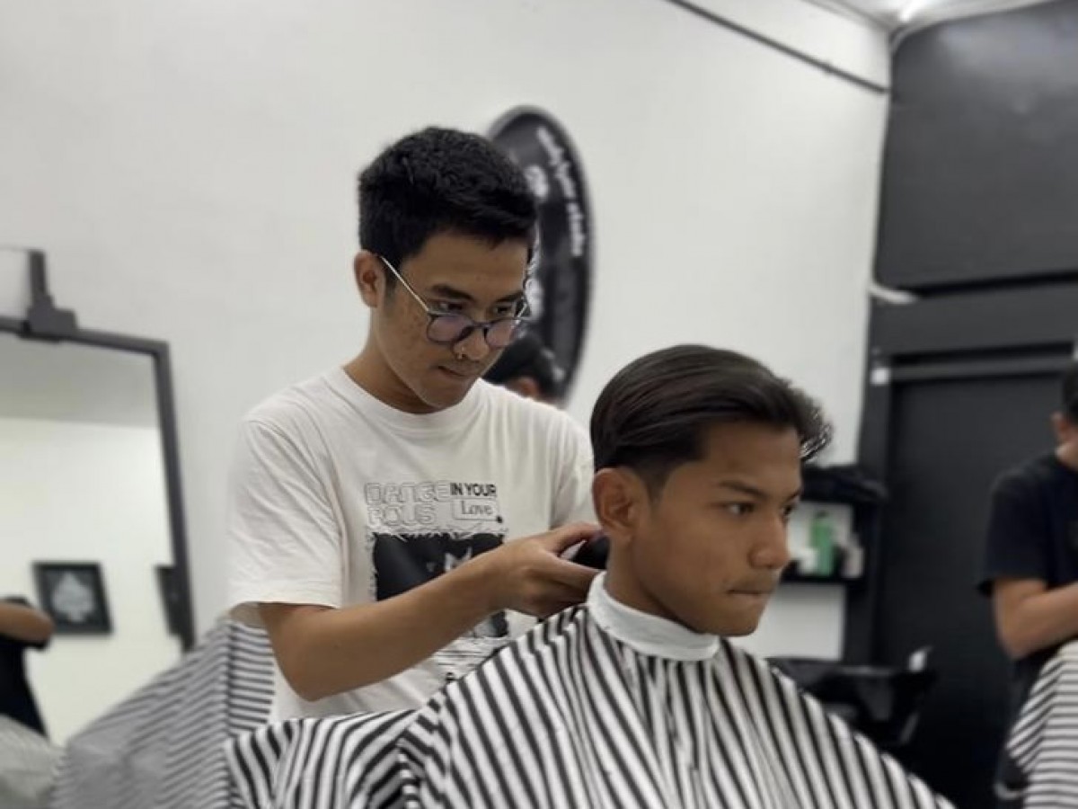 Ragil Nugroho sedang menyukur rambut Riyatno Abiyoso