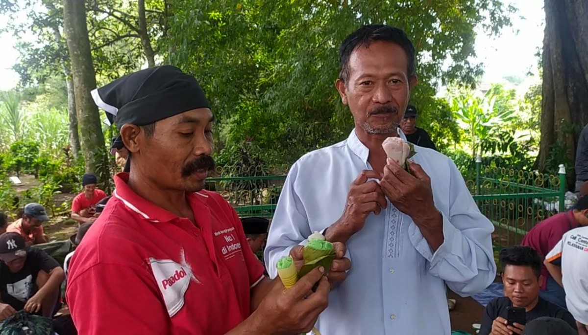 Dusun Banjarsari, Desa/Kecamatan Bareng, Kabupaten Jombang menunjukkan cara mengonsumsi kue clorot. (foto: Elok Aprianto/jatimnow.com)