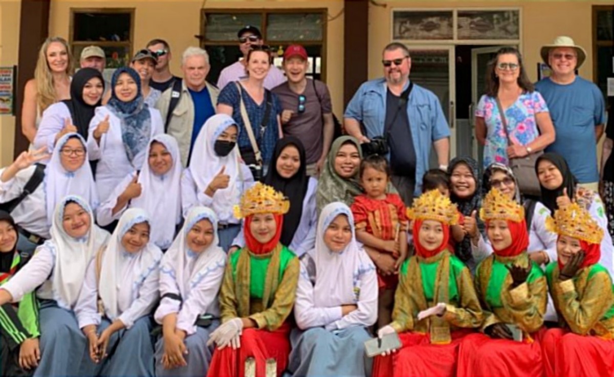 Para turis asing sedang berfoto bersama para siswa di Pulau Bawean (Foto: MTs Umar Masud for jatimnow.com)