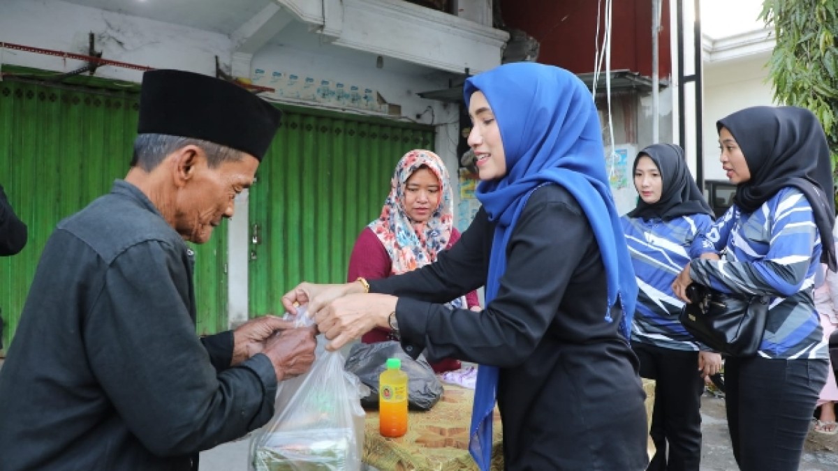 Ketua TP PKK Sampang, Mimin Slamet Junaidi membagikan paket sembako kepada penarik becak. (foto: Humas Pemkab Sampang for jatimnow.com)