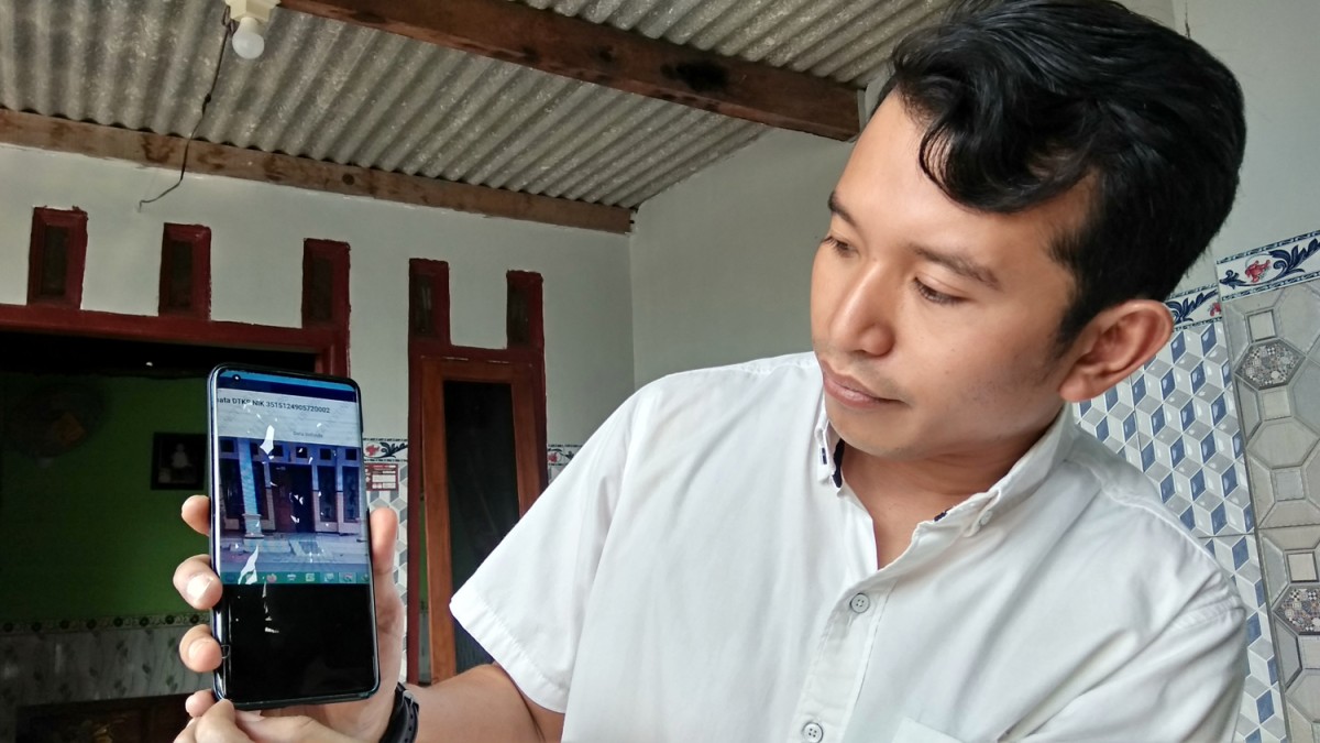 Anggota Komisi E DPRD Jatim Adam Rusydi menunjukkan foto rumah yang tidak sesuai di DTKS. (Achmad Supriyadi/jatimnow.com)