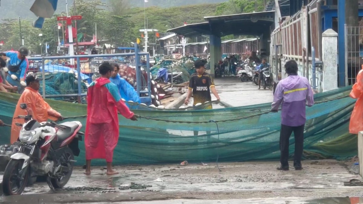 Nelayan memperbaiki jaring ikan. (Foto: Bramanta Pamungkas/jatimnow.com)