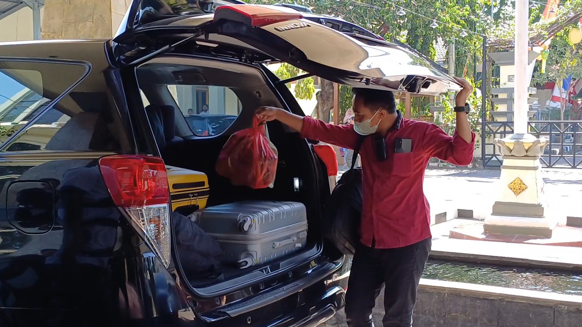 Penyidik KPK membawa sejumlah koper ke dalam mobil usai penggeledahan di Dinas Perkim Lamongan.