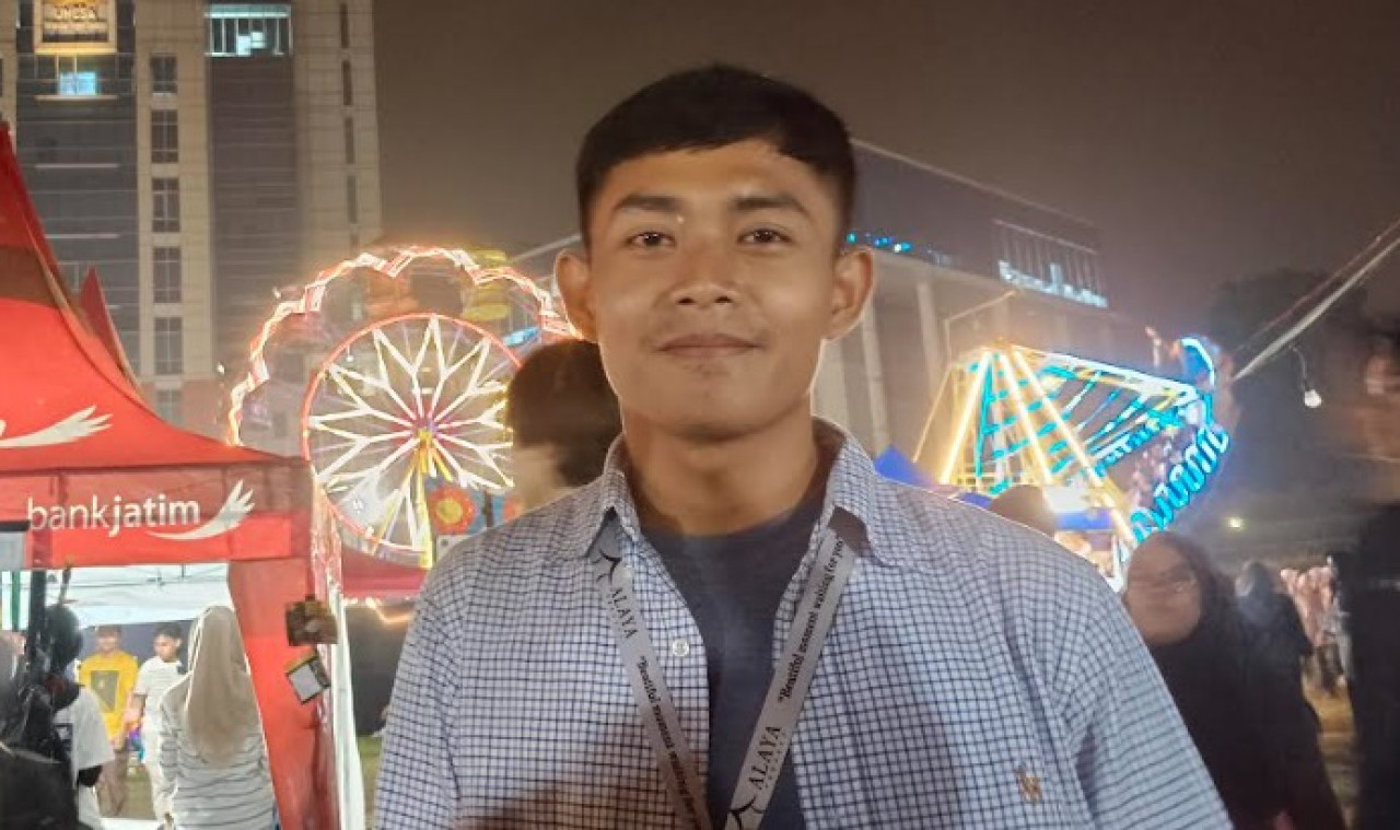 Ketua pelaksana Satrio Agung Prambudi saat mengajak berkeliling di deretan booth pameran UKM Unesa. (Foto: Misbahul Munir/jatimnow.com)