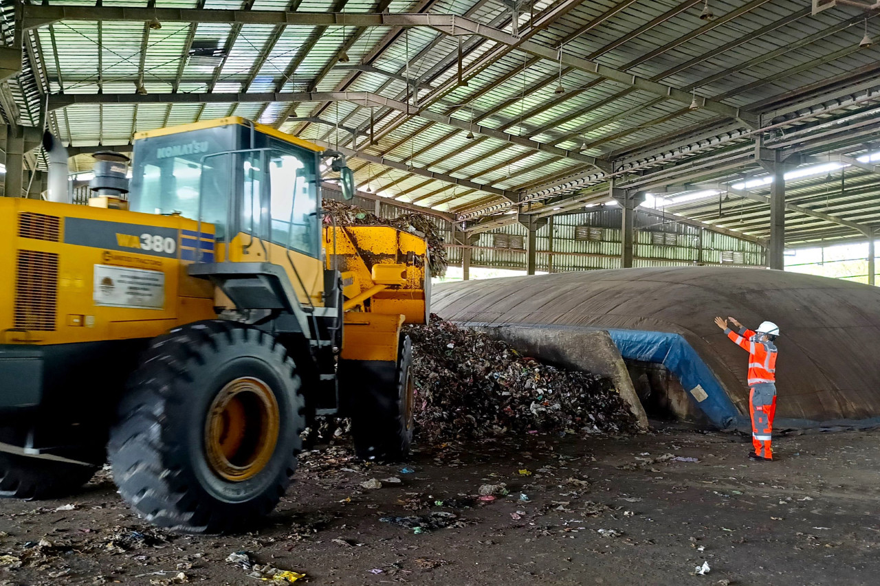 Proses pemindahan sampah basah hasil pencacahan ke tempat pengeringan yang akan diolah menjadi RDF dengan metode biodrying di fasilitas pengolahan sampah menjadi bahan bakar alternatif di Kabupaten Cilacap, Jawa Tengah.