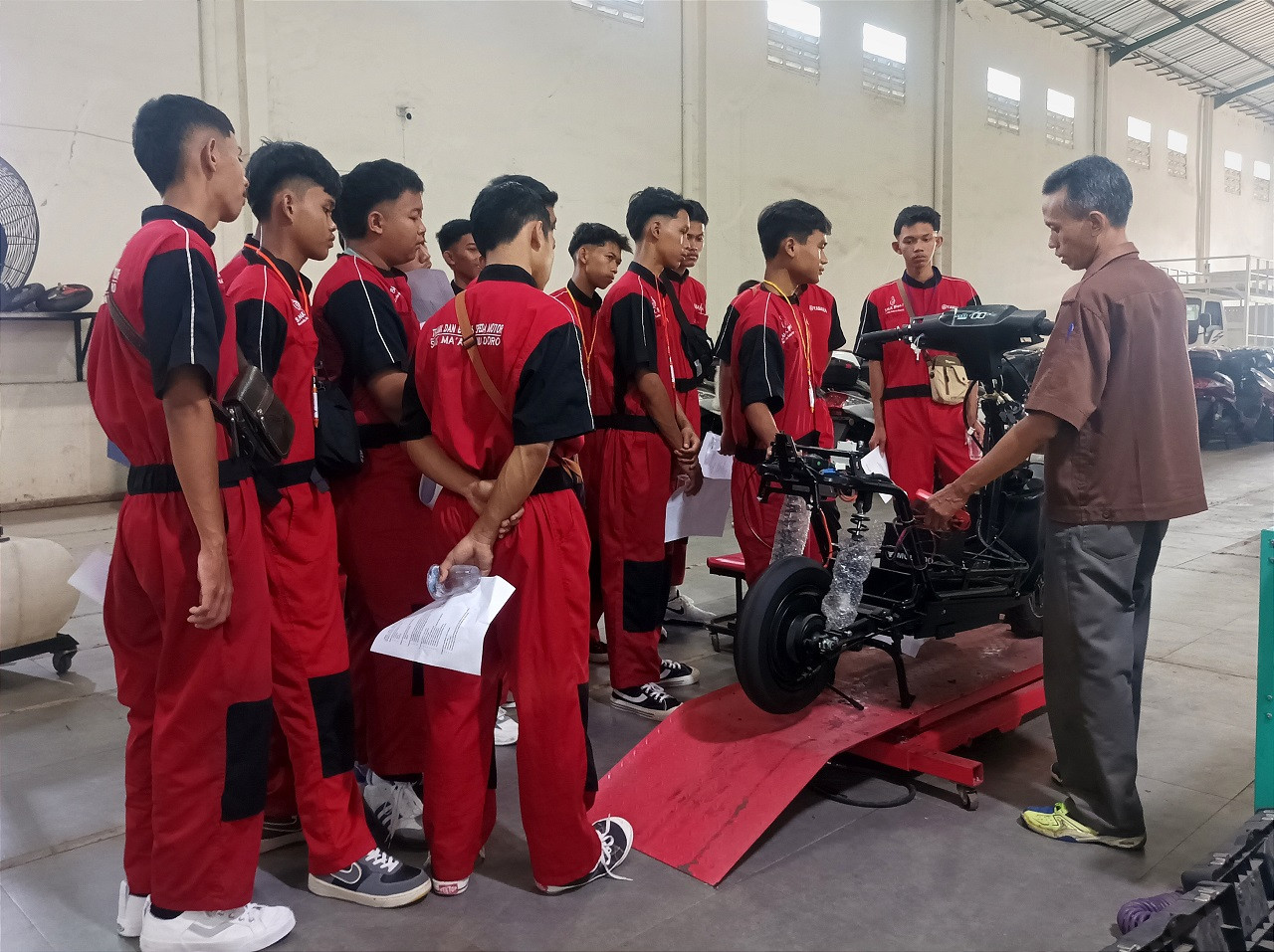 Para siswa SMK NU Ma'arif Doro Pekalongan sedang mendapat penjelasan dari teknisi sepeda motor listrik Molindo. (Foto: Sahlul Fahmi/jatimnow.com)