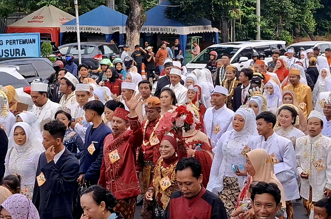 Senyum semringah para pengantin saat diarak. (
