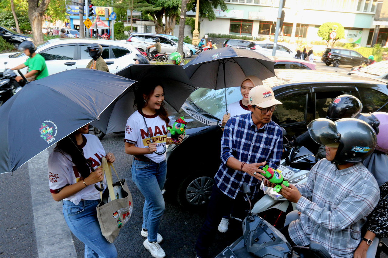 Nur Salam bersama model cantik menghampiri pengguna jalan Surabaya (foto: Ni'am Kurniawan/jatimnow.com)