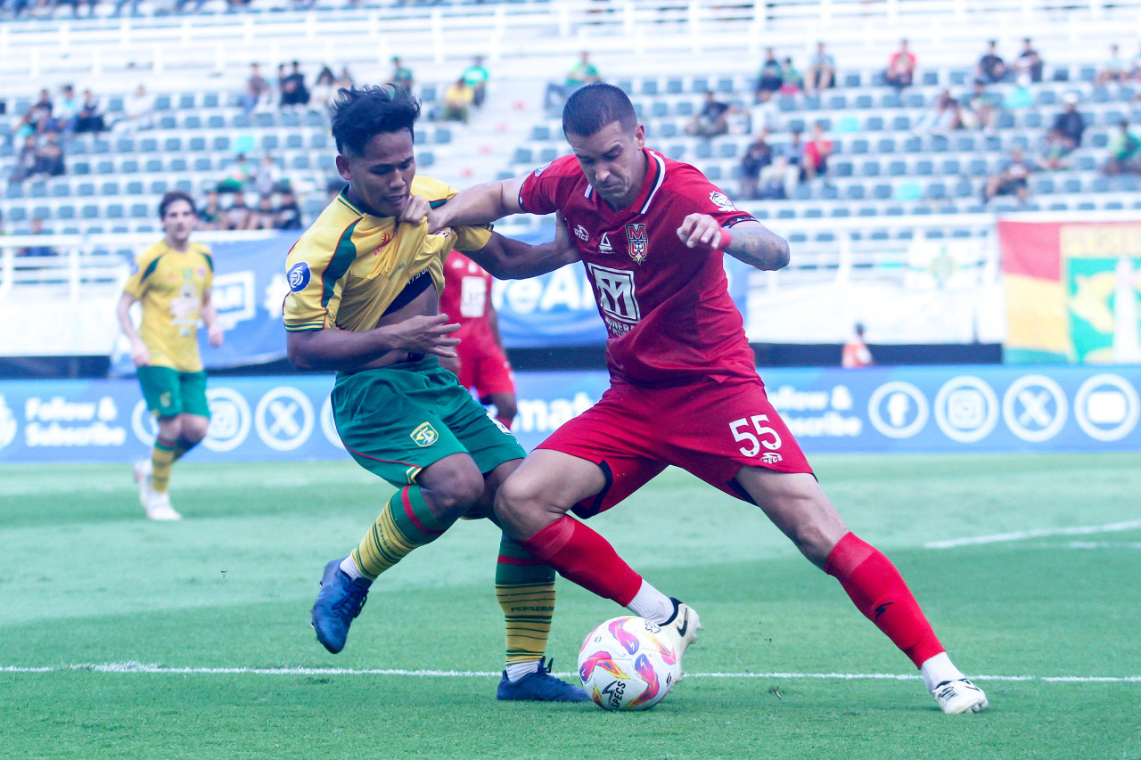 Pemain muda Persebaya Toni Firmansyah berduel dengan pemain asing Malut United Jesus Maria Meneses Sabater