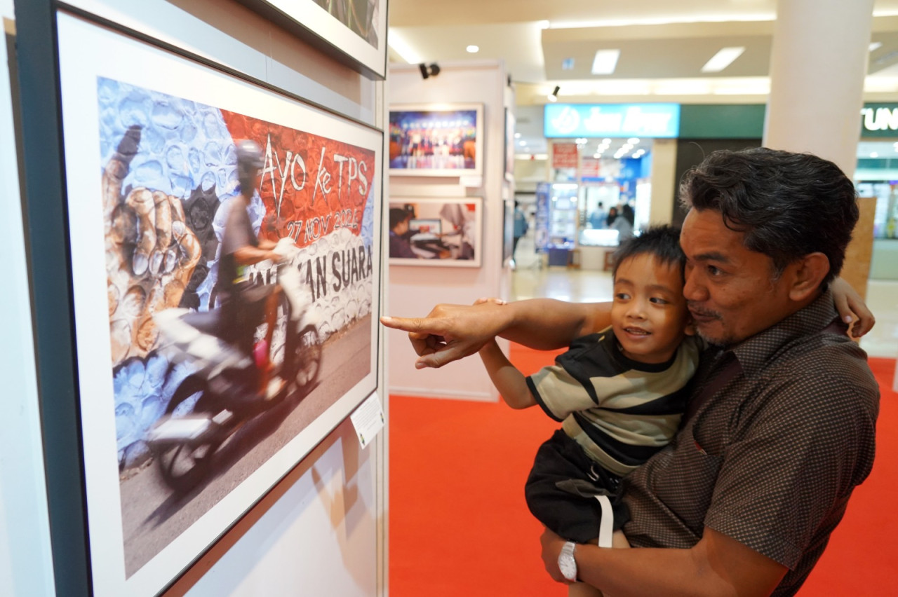 Pengunjung pameran foto dan karikatur Pilkada Serentak 2024 di Jawa Timur.