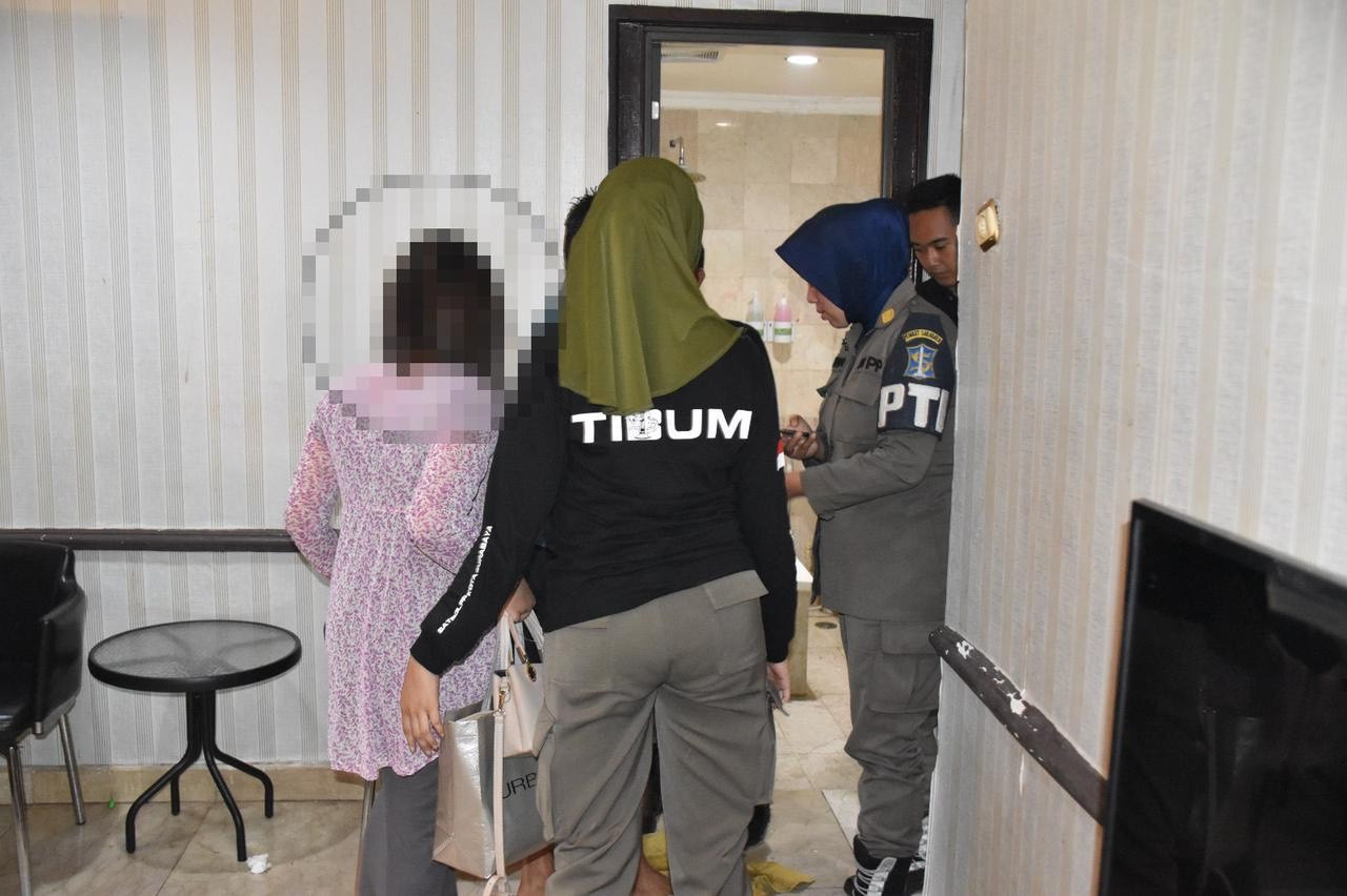 Sosok perempuan diamankan petugas dari dalam kamar hotel (foto: Satpol PP Surabaya for jatimnow.com)