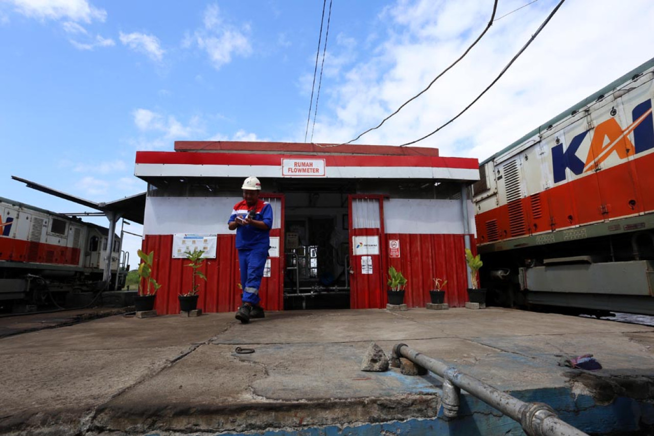Operator Pertamina Patra Logistik keluar dari  rumah pompa penyaluran usai melakukan pengisian bahan bakar minyak (BBM) jenis bio solar pada lokomotif Kereta Api, di  Depo Lokomotif Sidotopo, Surabaya, Jawa Timur, Selasa (29/7/2025). Foto: Ali Masduki/JatimNow.com