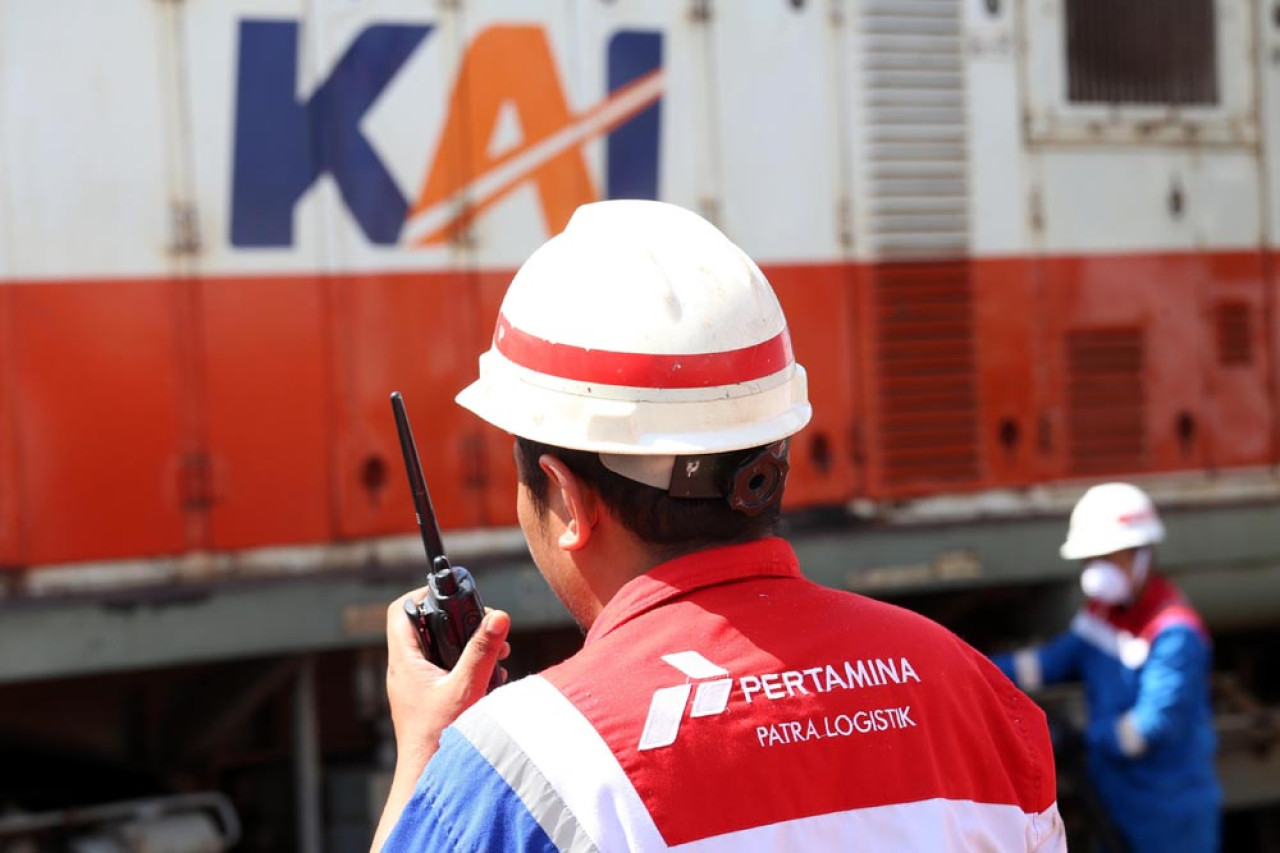 Operator Pertamina Patra Logistik berkomunikasi lewat Handy Talky (HT) dengan petugas daily check ketika proses pengisian bahan bakar minyak (BBM) lokomotif di Depo Lokomotif Sidotopo, Surabaya, Jawa Timur, Selasa (29/7/2025). Foto: Ali Masduki/JatimNow.com