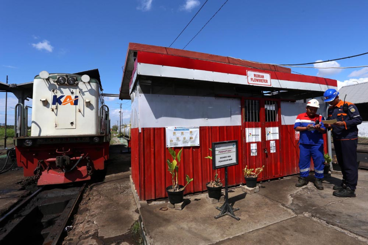 Petugas daily check menyerahkan nota kuota bahan bakar minyak (BBM) lokomotif kepada operator Pertamina Patra Logistik, di rumah pompa penyaluran ketika proses pengisian BBM di Depo Lokomotif Sidotopo, Surabaya, Jawa Timur, Selasa (29/7/2025). Foto: Ali Masduki/JatimNow.com