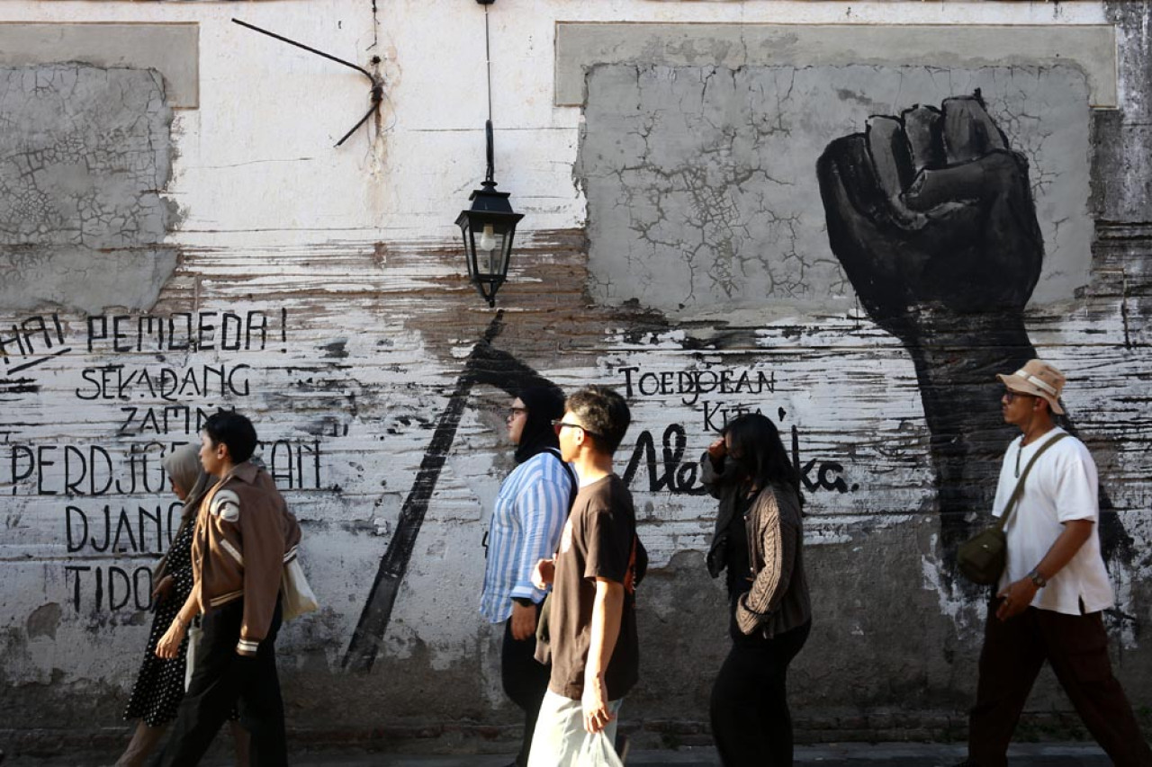 Wisatawan berjalan-jalan menikmati suasana masa lalu di kawasan kota lama Surabaya.  Foto: Ali Masduki/JatimNow.com