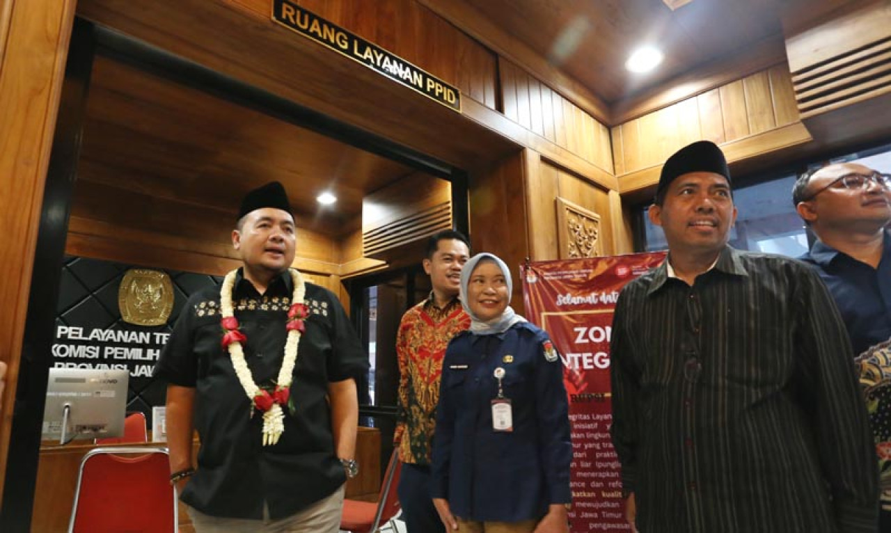 Ketua KPU RI, Mochammad Afifuddin, didampingi Sekretaris KPU Jatim Nanik Karsini, usai meninjau ruang layanan PPID, saat akan meresmikan Studio Podcast KPU Jatim. Foto: Ali Masduki/JatimNow.com