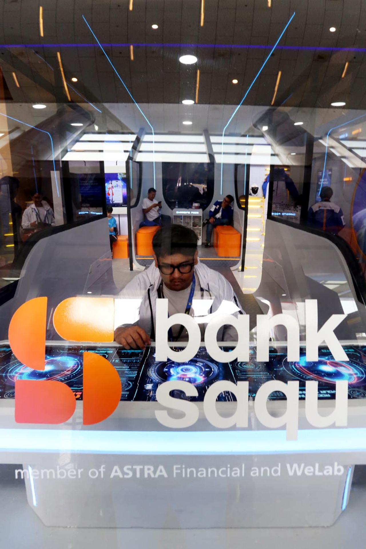 Pengunjung bermain di dalam armada Busposito Bank Saqu, di GIIAS Surabaya 2025. Bank Saqu adalah bagian dari Astra Financial, divisi jasa keuangan PT Astra International Tbk. (Foto: Ali Masduki/JatimNow.com)