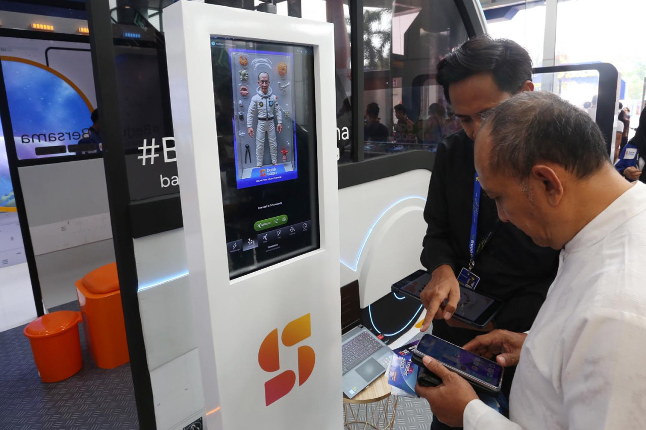 Pengunjung melakukan registrasi akun di armada Busposito Bank Saqu, di GIIAS Surabaya 2025. Bank Saqu adalah bagian dari Astra Financial, divisi jasa keuangan PT Astra International Tbk. (Foto: Ali Masduki/JatimNow.com)