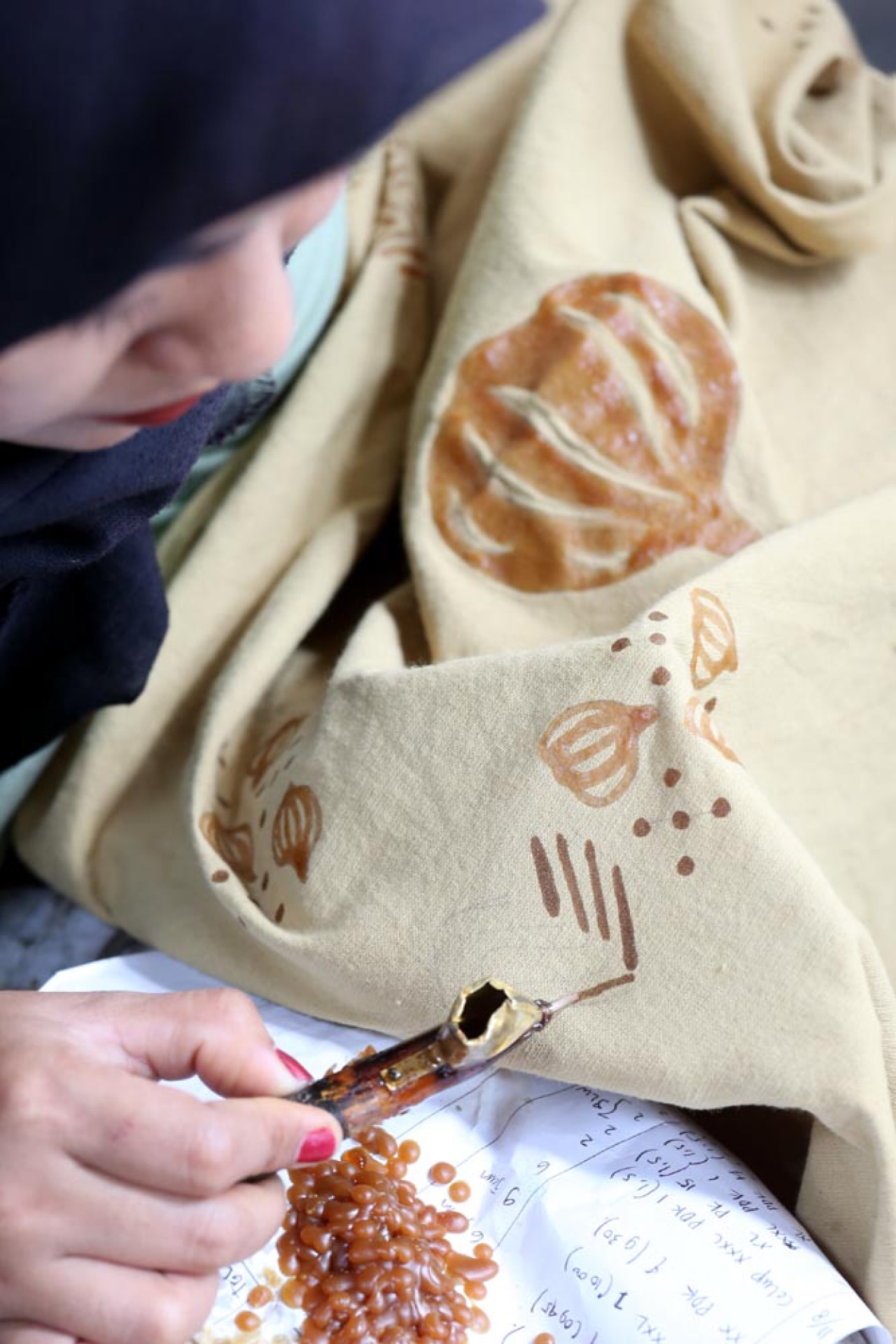 Pekerja menyelesaikan proses batik dengan motif bawang, di Workshop Ulur Wiji, di Desa Pandankrajan, Kabupaten Mojokerto, Jawa Timur. (Foto: Ali Masduki/JatimNow.com)