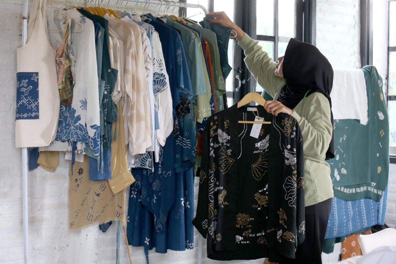 Pekerja merapikan beragam produk batik kontemporer, di Workshop Ulur Wiji, di Desa Pandankrajan, Kabupaten Mojokerto, Jawa Timur. (Foto: Ali Masduki/JatimNow.com)