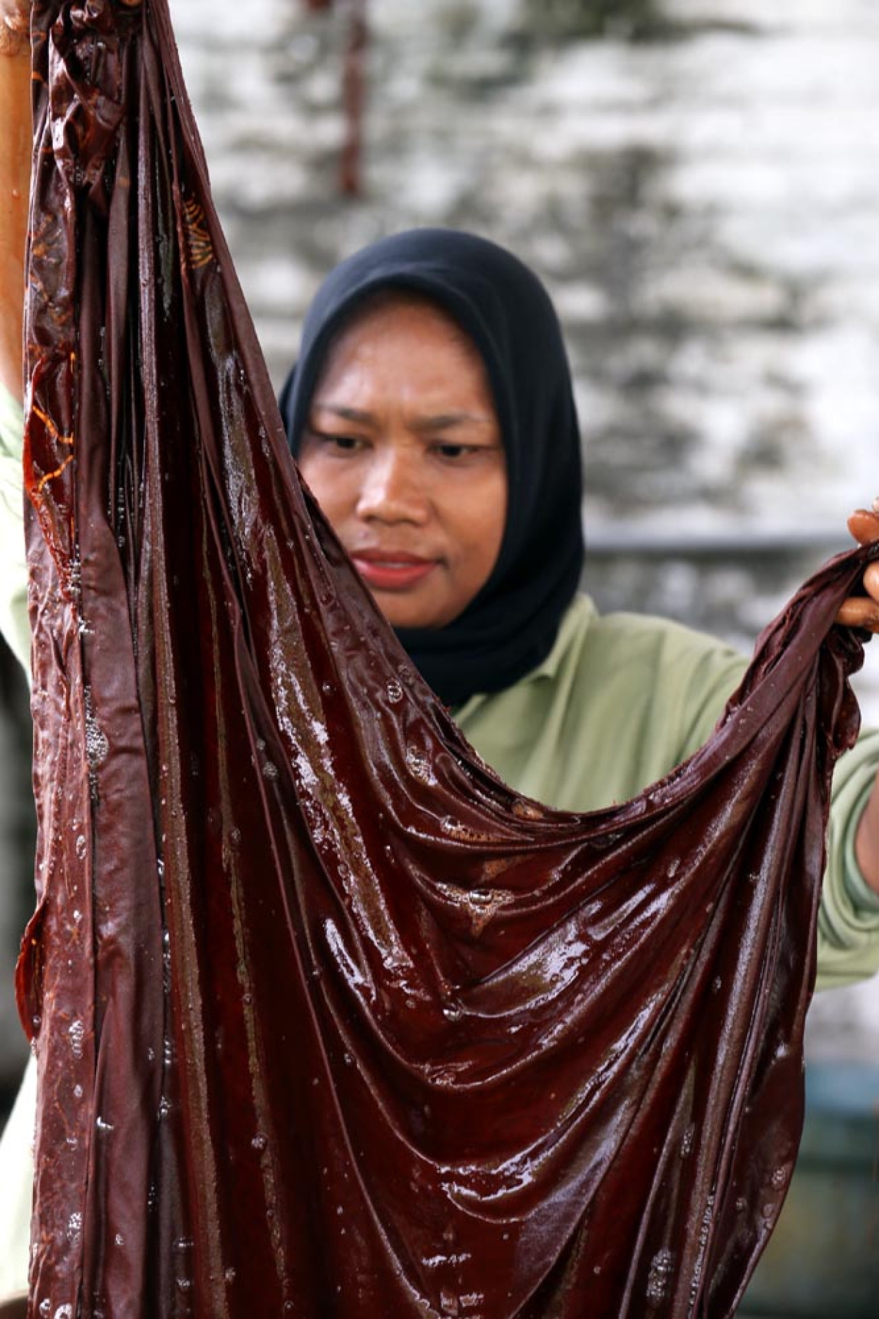 Pekerja menyelesaikan proses pewarnaan batik di Workshop Ulur Wiji, di Desa Pandankrajan, Kabupaten Mojokerto, Jawa Timur. (Foto: Ali Masduki/JatimNow.com)