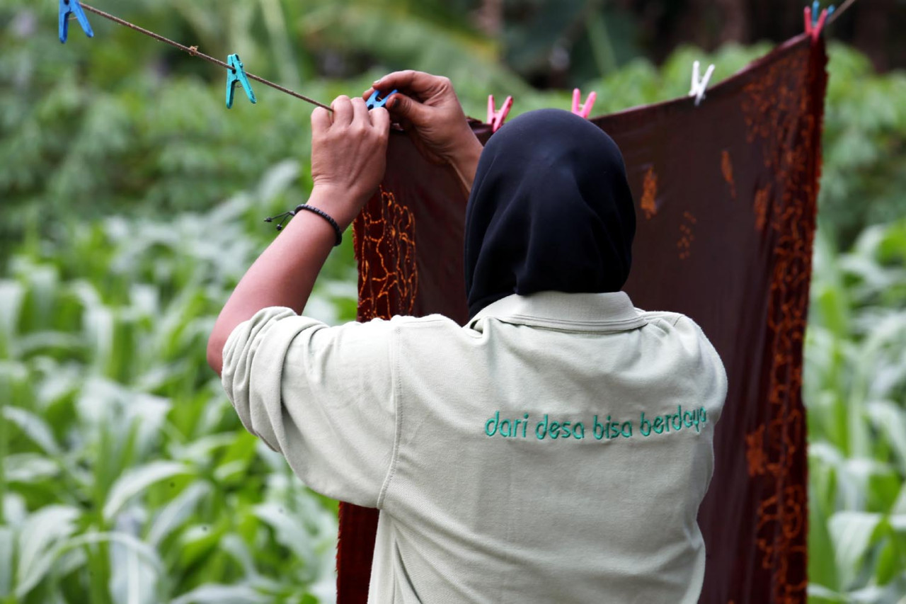 Pekerja menjemur batik di Workshop Ulur Wiji, di Desa Pandankrajan, Kabupaten Mojokerto, Jawa Timur. (Foto: Ali Masduki/JatimNow.com)