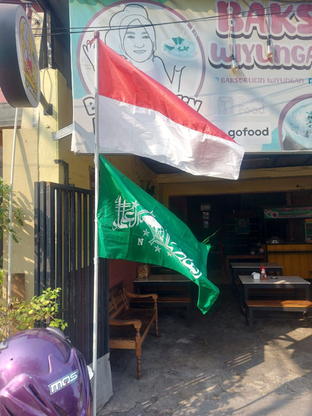 Bendera merah putih dan bendera NU berdiri di depan Kedai Bucin, Wiyung, Surabaya, Selasa (05/8/2025). Foto: Bucin for JatimNow.com 