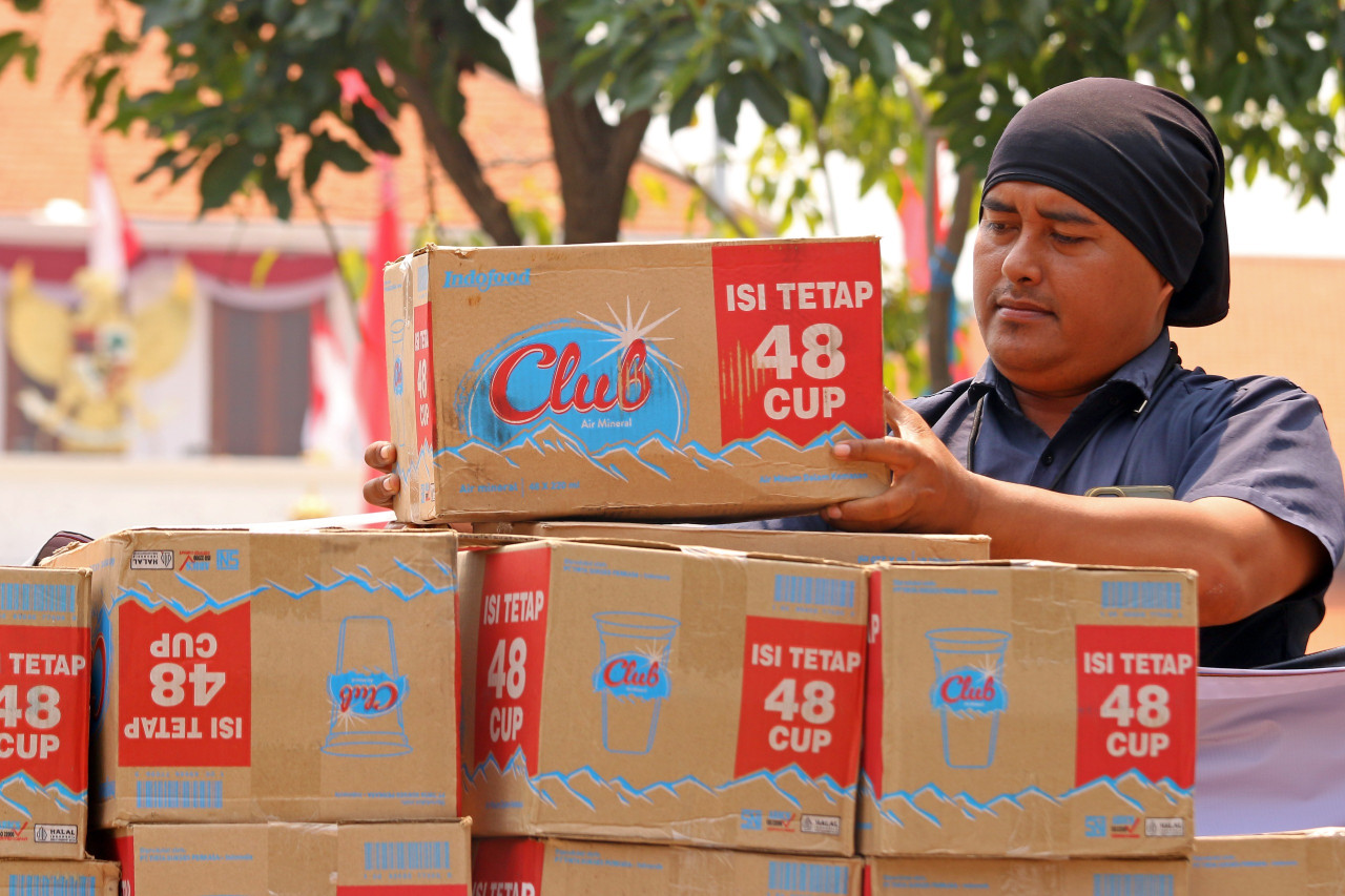 Relawan Posko Rakyat Jawa Timur menumpuk donasi air mineral (foto: Iffan/jatimnow.com)
