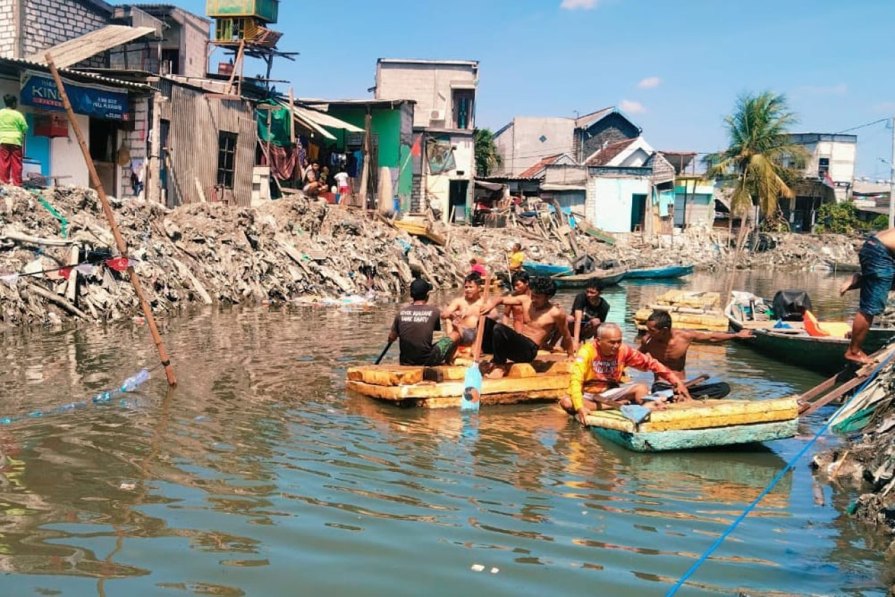 Sisa normalisasi sungai dan tumpukkan sampah masih tersisa di sisi kanan-kiri sungai