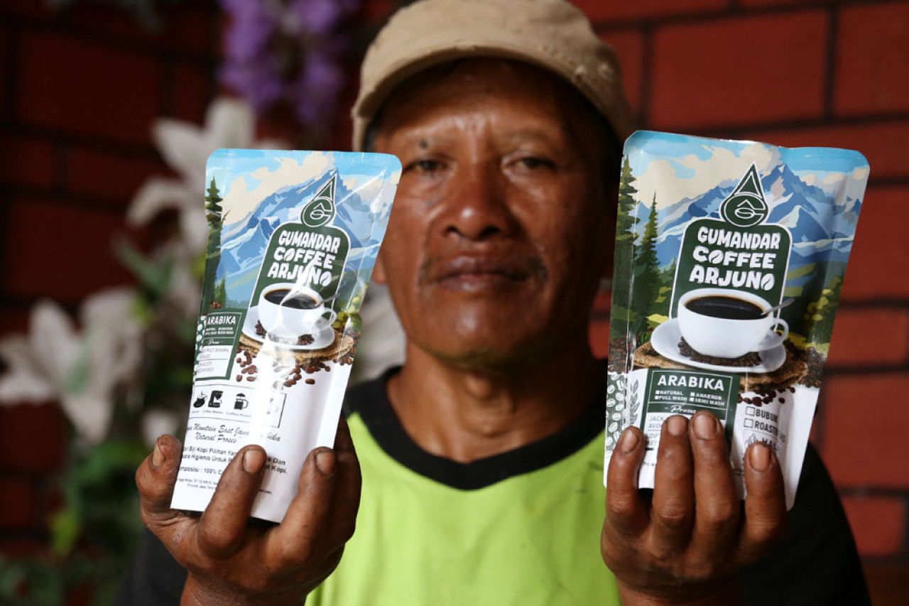 Ketua LPHD Arjuna Lestari, Hidayat, menunjukkan bubuk kopi Arabika kemasan siap jual di Dusun Tegal Kidul, Desa Jatiarjo, Kecamatan Prigen, Kabupaten Pasuruan, Jawa Timur, Senin (04/8/2025). Bubuk kopi Arabika ini dipasarkan dengan harga Rp75.000 per 250 gram. Foto: Ali Masduki/JatimNow.com