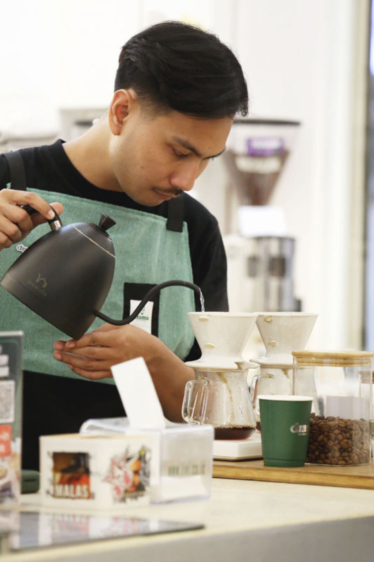 Barista menyajikan kopi Arabika di Cafe Drama Roastery, Jl. Tunjungan Surabaya, Jawa Timur, Senin (04/8/2025). Cafe berjejaring ini merupakan salah satu pengguna kopi Arabika dari Lereng Gunung Arjuna. Foto: Ali Masduki/JatimNow.com